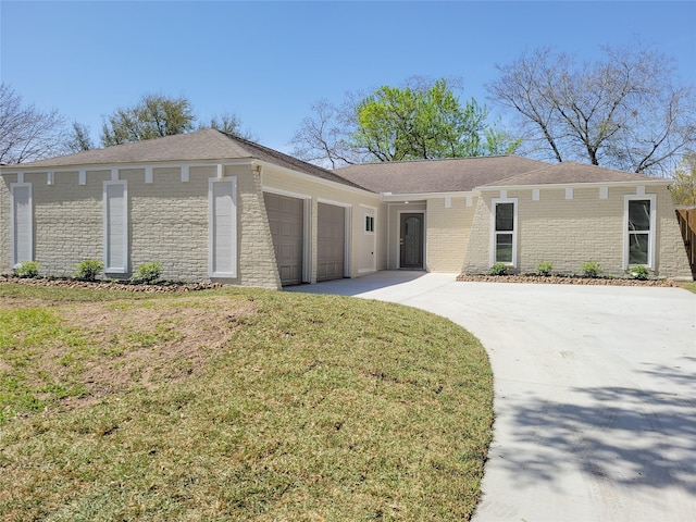 view of front of house featuring brick siding, driveway, an attached garage, and a front lawn