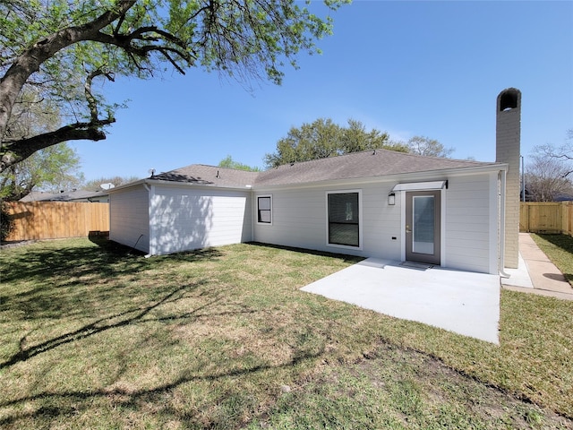 back of house with a patio area, a yard, a fenced backyard, and a chimney