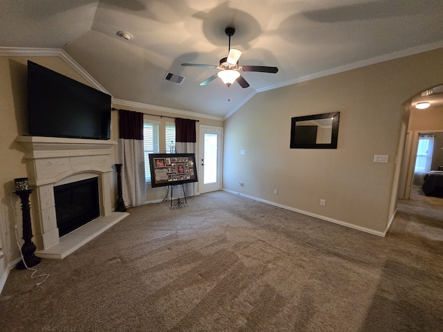 unfurnished living room with a fireplace with raised hearth, crown molding, lofted ceiling, carpet flooring, and a ceiling fan