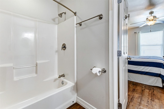 bathroom featuring baseboards, bathing tub / shower combination, wood finished floors, ensuite bath, and a ceiling fan