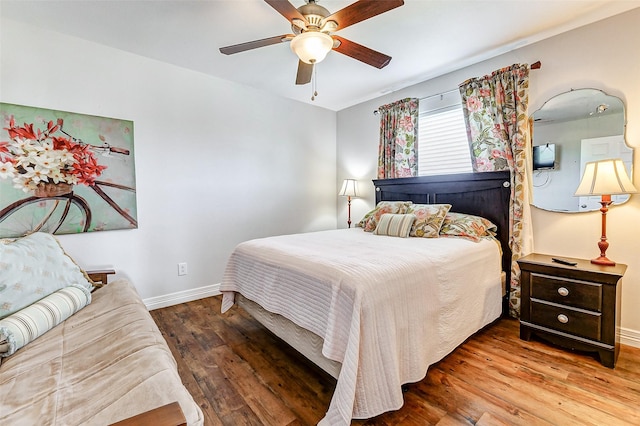 bedroom with wood finished floors, baseboards, and ceiling fan