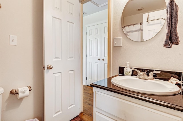 bathroom featuring toilet, wood finished floors, and vanity