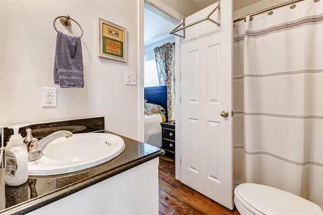 full bathroom with vanity, wood finished floors, ensuite bathroom, curtained shower, and toilet