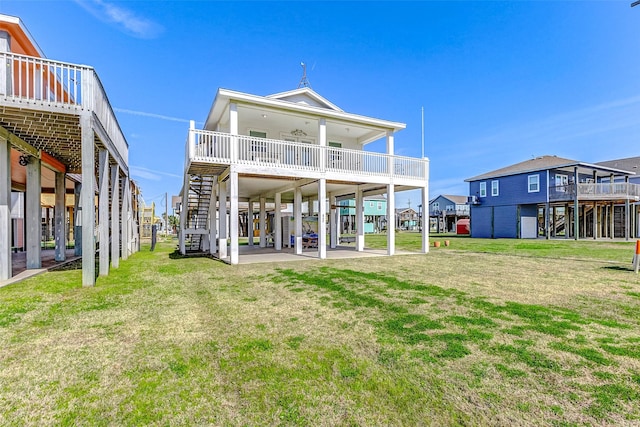 back of house featuring a yard, a carport, stairs, and a patio area