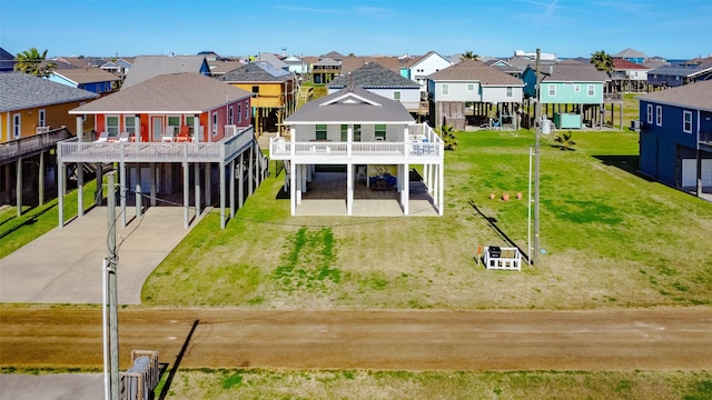 rear view of property featuring a carport, a residential view, concrete driveway, and a yard