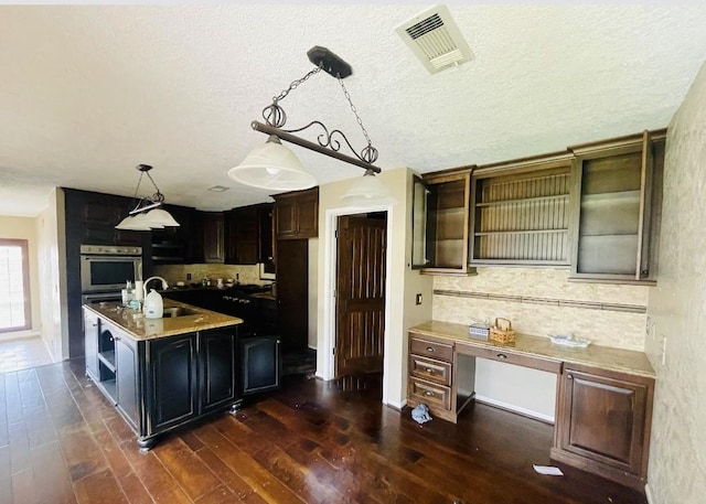 kitchen featuring visible vents, open shelves, a sink, backsplash, and dark wood-style flooring