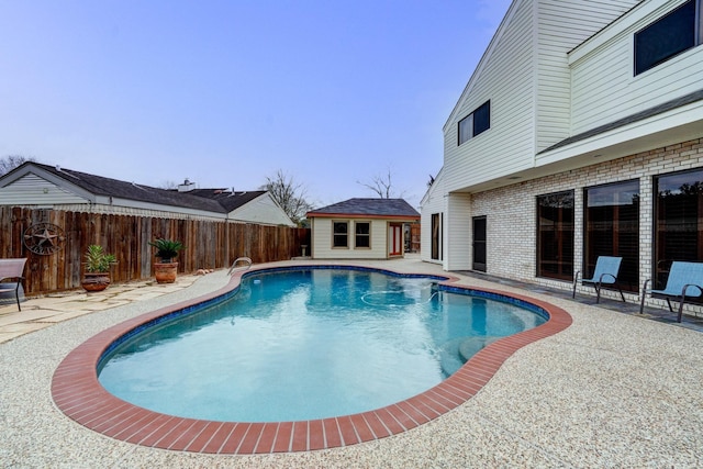 view of pool with an outdoor structure, a patio area, a fenced in pool, and a fenced backyard