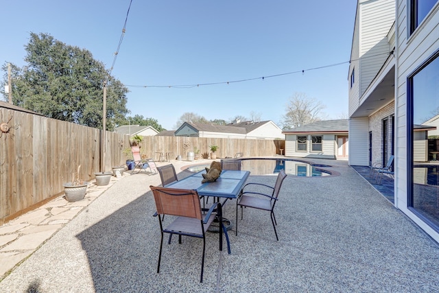 view of patio with outdoor dining space, a fenced backyard, and a fenced in pool