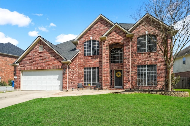 traditional-style house featuring fence, a front lawn, concrete driveway, a garage, and brick siding