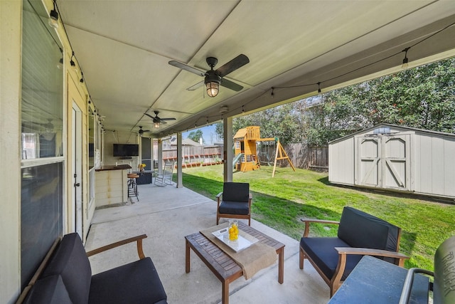 view of patio / terrace with a fenced backyard, a storage unit, a playground, and an outdoor structure