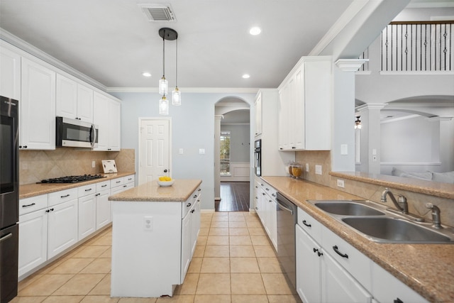 kitchen with visible vents, arched walkways, stainless steel appliances, ornate columns, and a sink