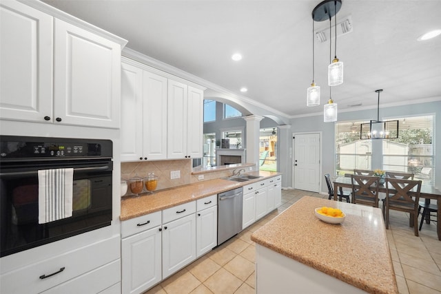 kitchen with ornate columns, arched walkways, decorative backsplash, dishwasher, and black oven