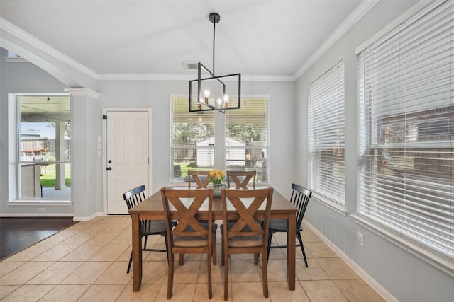 dining room with light tile patterned floors, a notable chandelier, crown molding, and decorative columns