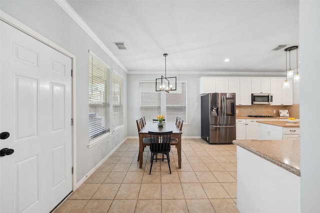 dining room with crown molding, a notable chandelier, light tile patterned flooring, and visible vents