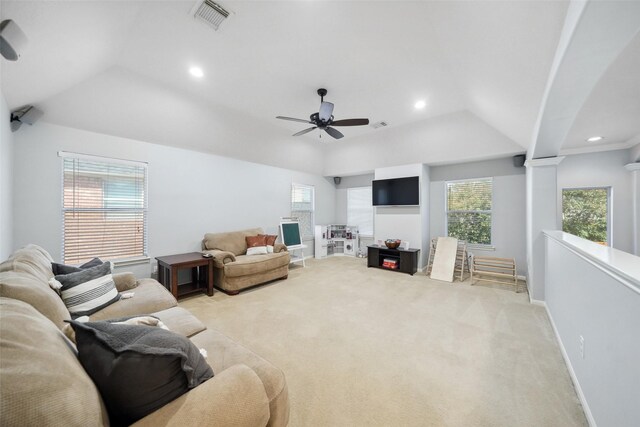 living room with visible vents, baseboards, decorative columns, vaulted ceiling, and light colored carpet