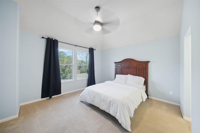 bedroom with a ceiling fan, vaulted ceiling, light colored carpet, and baseboards