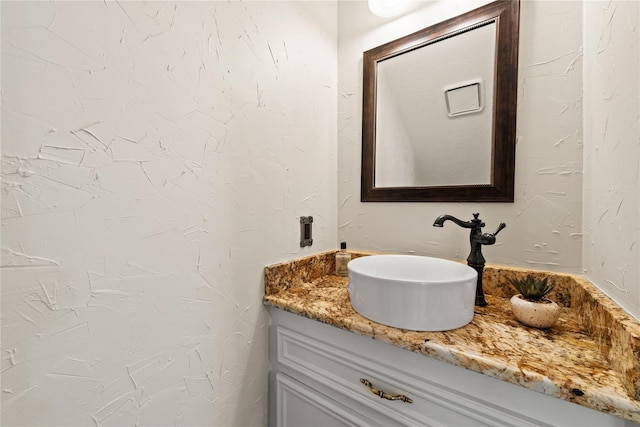 bathroom with vanity and a textured wall