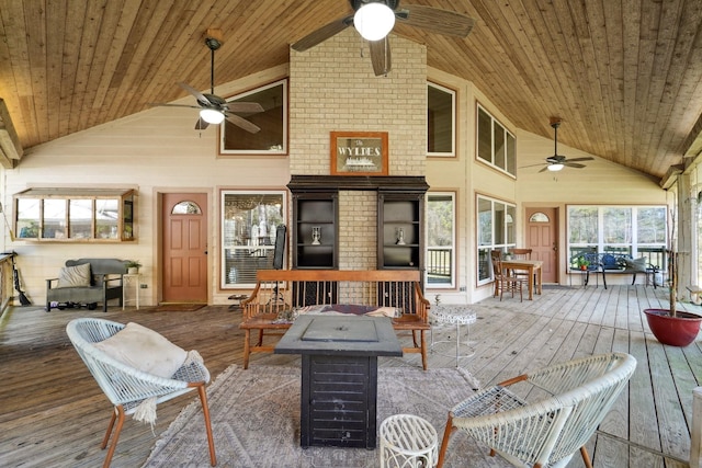 wooden deck with a ceiling fan and a fire pit