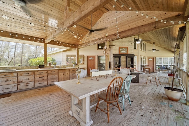 wooden deck with a sink, outdoor dining area, outdoor dry bar, and a ceiling fan