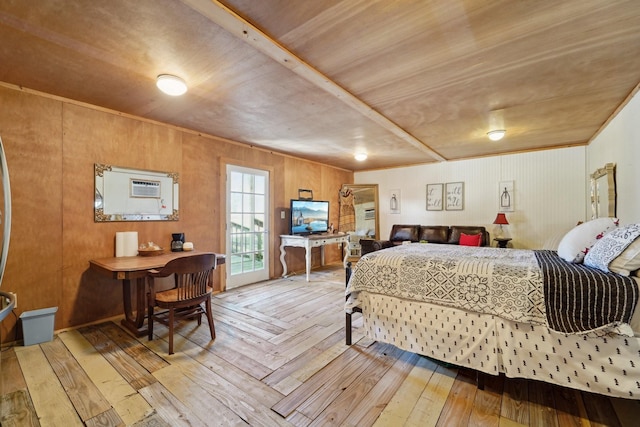 bedroom featuring hardwood / wood-style floors and a wall unit AC