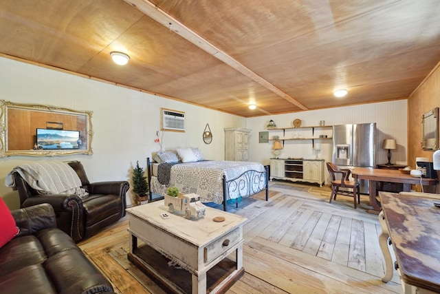 bedroom featuring a wall unit AC, light wood-style floors, and stainless steel refrigerator with ice dispenser