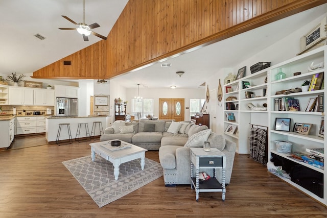 living area featuring visible vents, high vaulted ceiling, dark wood-style floors, and ceiling fan with notable chandelier