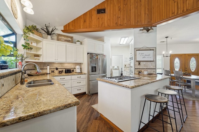 kitchen featuring dark wood-style floors, high vaulted ceiling, open shelves, a sink, and appliances with stainless steel finishes