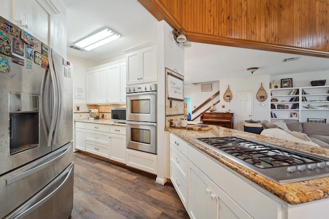 kitchen featuring visible vents, open floor plan, dark wood finished floors, appliances with stainless steel finishes, and white cabinets