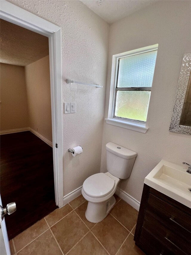 bathroom featuring vanity, tile patterned floors, toilet, and baseboards