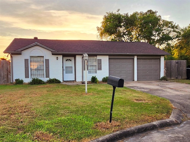 ranch-style home with driveway, an attached garage, a front yard, and fence