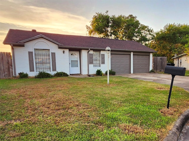 ranch-style house featuring concrete driveway, fence, a garage, and a lawn