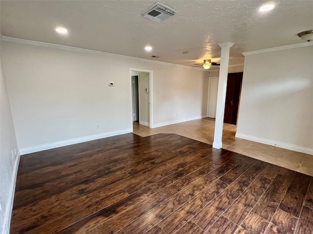 empty room featuring visible vents, baseboards, ceiling fan, ornamental molding, and wood finished floors