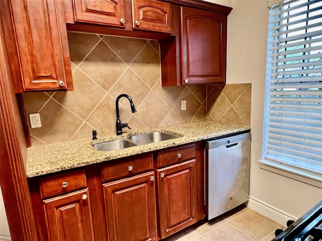 kitchen with a sink, decorative backsplash, light stone countertops, and dishwasher