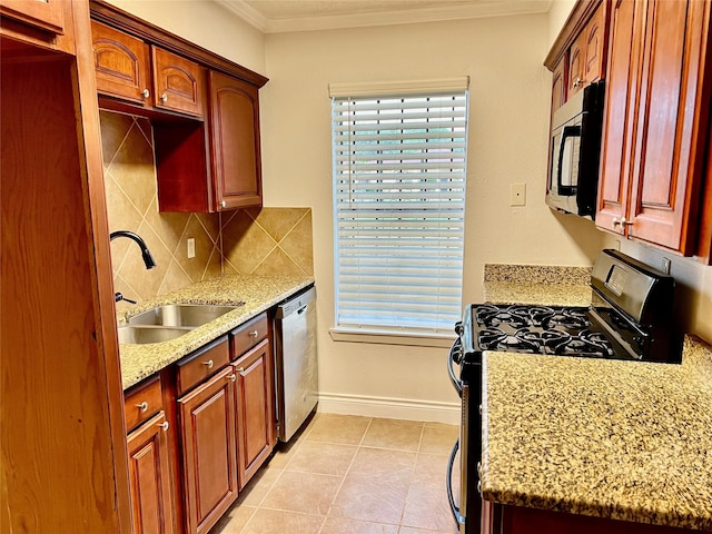 kitchen featuring baseboards, ornamental molding, decorative backsplash, black appliances, and a sink