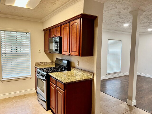 kitchen with gas stove, a textured ceiling, ornamental molding, and black microwave