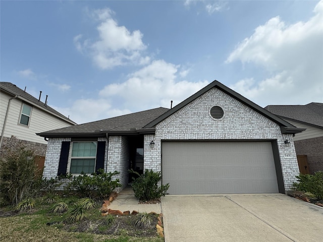 view of front facade featuring an attached garage, brick siding, driveway, and a shingled roof