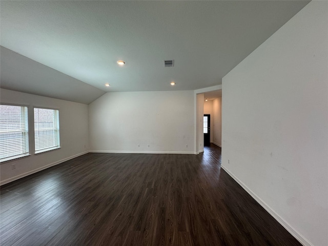 unfurnished room with visible vents, dark wood-type flooring, baseboards, vaulted ceiling, and recessed lighting