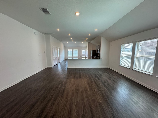 unfurnished living room with dark wood-type flooring, baseboards, visible vents, and a sink