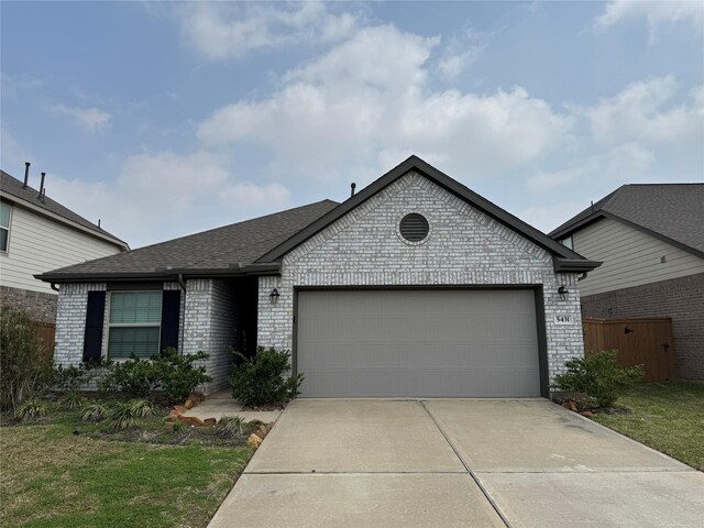 view of front of property with brick siding, a garage, driveway, and roof with shingles