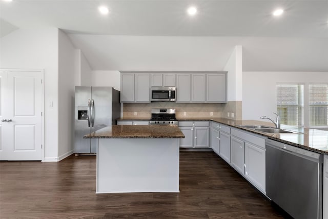 5431 Tourmaline Way, Brookshire, TX 77423 - kitchen with stainless steel appliances, a sink, vaulted ceiling, decorative backsplash, and dark stone counters