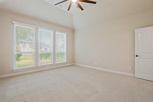 unfurnished room featuring ceiling fan, light colored carpet, baseboards, and vaulted ceiling