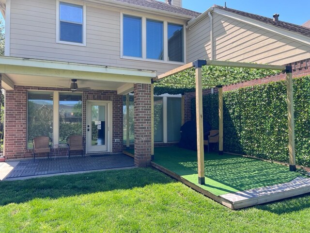 rear view of house featuring brick siding, a yard, and a patio area