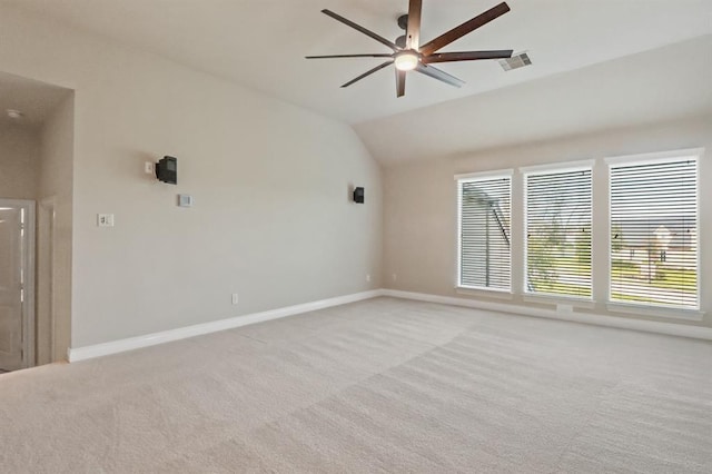 spare room featuring light carpet, lofted ceiling, ceiling fan, and baseboards