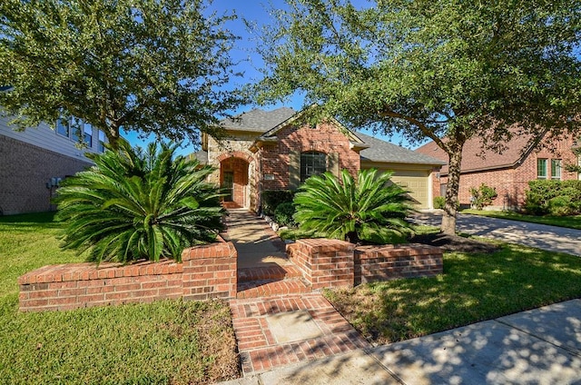 view of front of property with brick siding, an attached garage, driveway, and a front yard