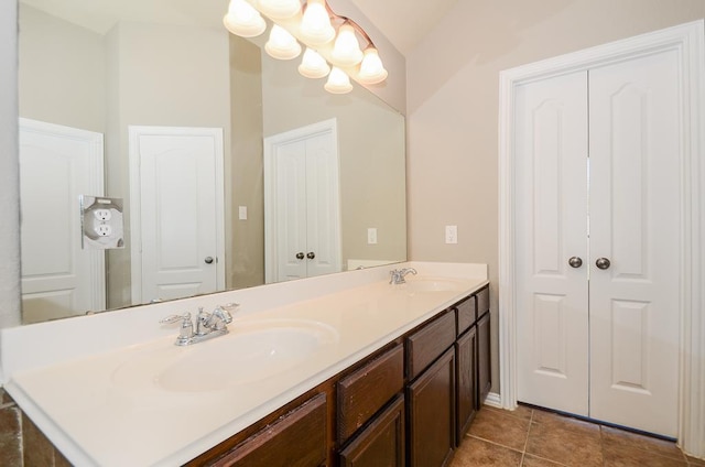 full bath with double vanity, a notable chandelier, tile patterned floors, and a sink