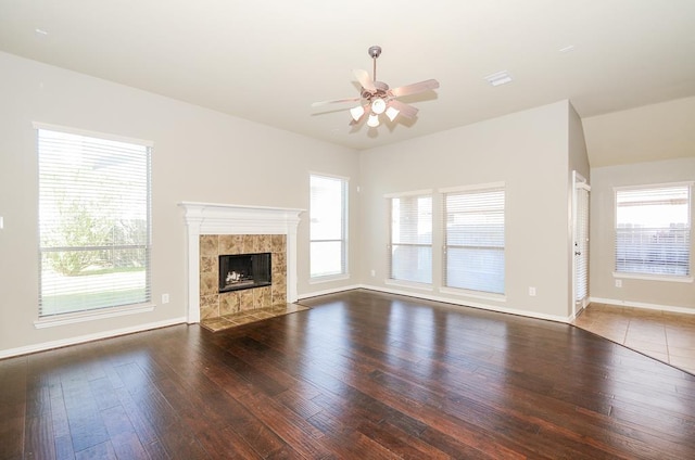 unfurnished living room with baseboards, a fireplace, a ceiling fan, and hardwood / wood-style flooring