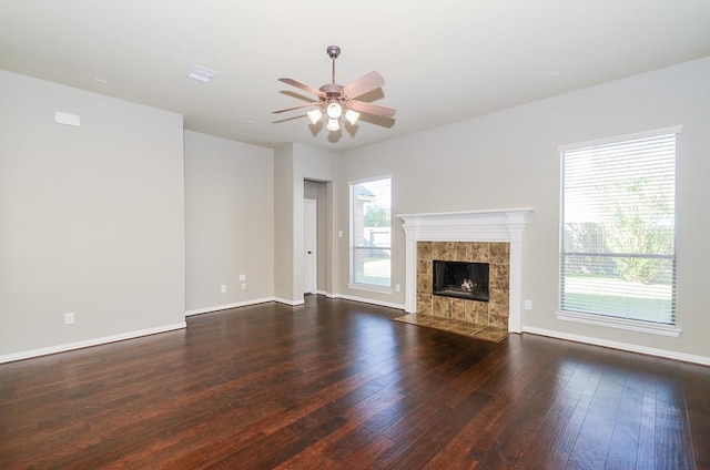 unfurnished living room featuring a fireplace, hardwood / wood-style flooring, a ceiling fan, and baseboards