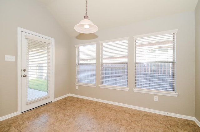 unfurnished room featuring vaulted ceiling, plenty of natural light, and baseboards