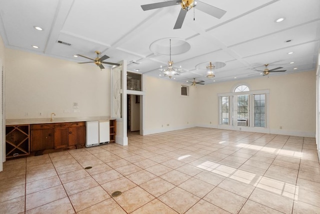 empty room with light tile patterned floors, a ceiling fan, visible vents, and coffered ceiling