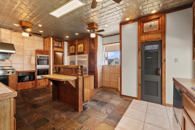 kitchen featuring wood counters, stainless steel fridge, double wall oven, and ceiling fan